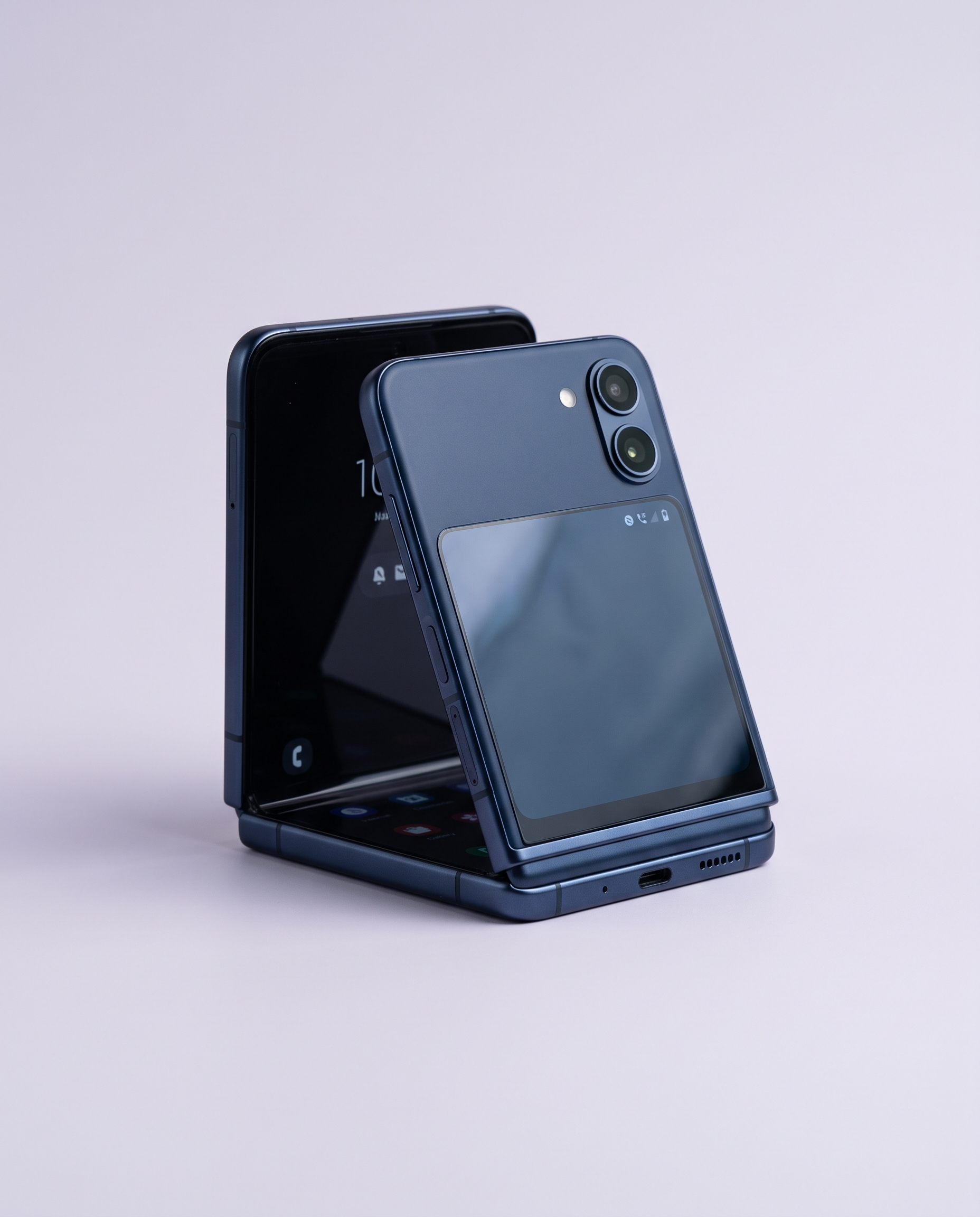 Navy flip phone standing half folded with its cover screen facing out