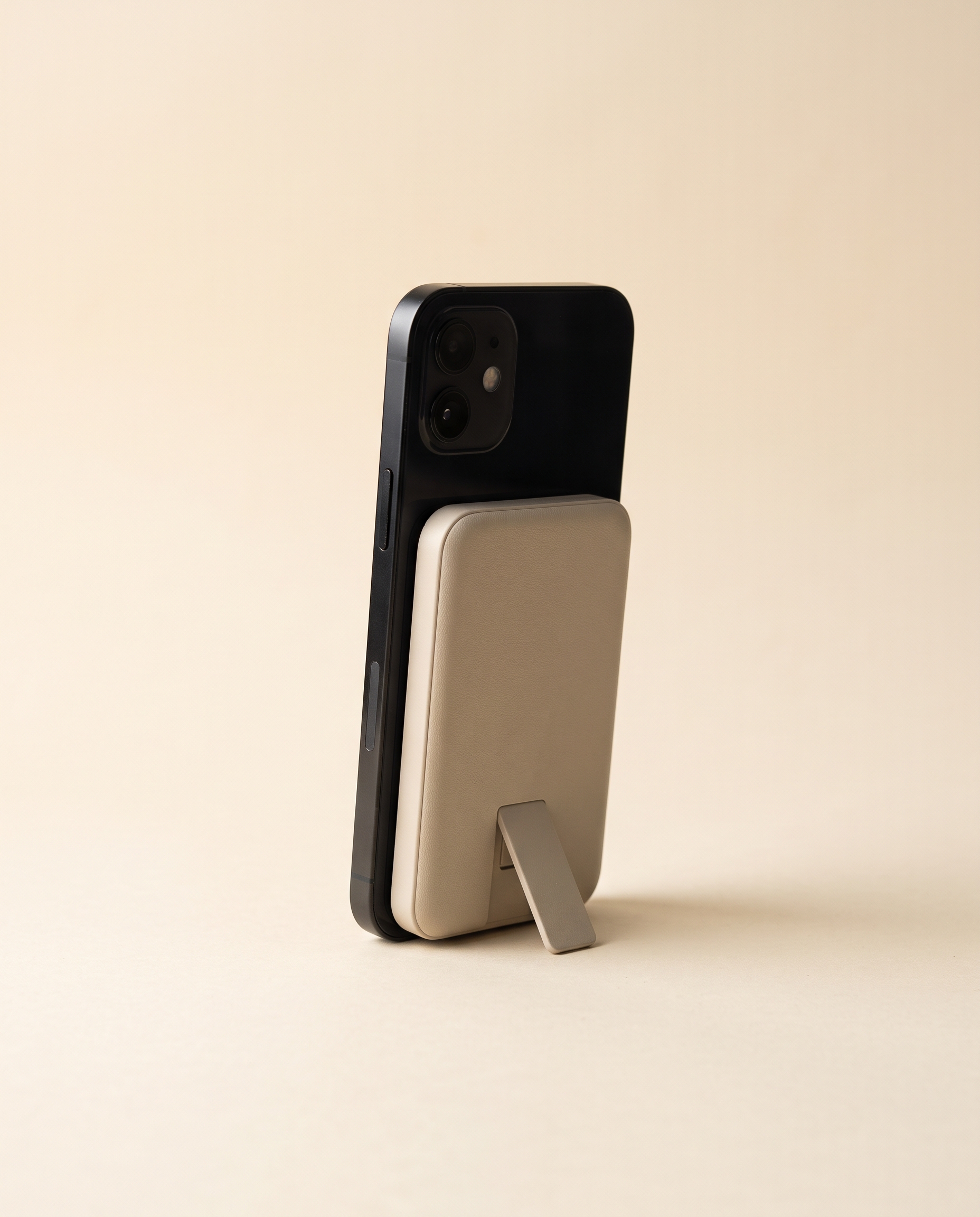Sand colored magnetic power bank attached to the back of a phone